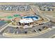 Aerial view of the community pool area with lounge chairs, a clubhouse, and parking at 4863 River Landing Ave, Firestone, CO 80504