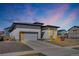 Modern home exterior featuring a gray garage door and well-maintained landscaping at 4863 River Landing Ave, Firestone, CO 80504