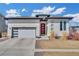 Contemporary home featuring a red front door, modern garage door, and xeriscaped yard at 4863 River Landing Ave, Firestone, CO 80504