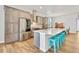 Open-concept kitchen with a large island, bar stool seating, and stainless steel appliances at 4863 River Landing Ave, Firestone, CO 80504