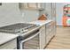 Close-up of the kitchen featuring stainless steel oven and stovetop, gray backsplash, and countertops at 4863 River Landing Ave, Firestone, CO 80504