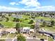 Aerial view of a suburban home situated on a golf course with lake and city views at 3930 S Pinehurst Cir, Denver, CO 80235