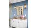 Bathroom with modern vanity, vessel sink, decorative mirror, and sconce lighting at 3930 S Pinehurst Cir, Denver, CO 80235