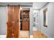Walk-in closet with a custom, natural wood door and built-in storage solutions for organization at 3930 S Pinehurst Cir, Denver, CO 80235