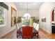 Elegant dining room with high ceilings, large windows, modern light fixture, and seating for eight at 3930 S Pinehurst Cir, Denver, CO 80235