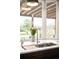 Bright kitchen showcasing marble counters, copper hardware, and a stunning window view of the yard at 3930 S Pinehurst Cir, Denver, CO 80235