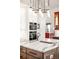 Stylish kitchen with a central island, stainless steel appliances, and elegant lighting fixtures at 3930 S Pinehurst Cir, Denver, CO 80235