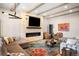Cozy living room with stone fireplace, hardwood floors, stylish seating, and abundant natural light at 3930 S Pinehurst Cir, Denver, CO 80235