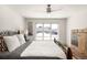 Bright bedroom featuring a ceiling fan, natural light from a large window, and an ornate bed frame at 3930 S Pinehurst Cir, Denver, CO 80235