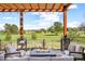 Inviting patio with a fire pit, comfortable seating, and a pergola overlooking a lush green golf course at 3930 S Pinehurst Cir, Denver, CO 80235