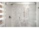 Modern glass-enclosed shower showcasing hexagon tile work, a rainfall shower head, and built in seating at 3930 S Pinehurst Cir, Denver, CO 80235