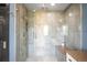 Stylish walk-in shower featuring sleek tile work, rainfall shower head, and glass doors at 3930 S Pinehurst Cir, Denver, CO 80235