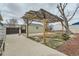 View of landscaped backyard featuring a covered patio area, detached garage, and gate at 7770 Kenwood St, Commerce City, CO 80022