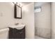 Cozy bathroom with a vanity sink and walk-in shower featuring modern tile and an overhead light at 7770 Kenwood St, Commerce City, CO 80022