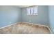 Light blue bedroom showing carpeted floors, and a large window providing natural light at 7770 Kenwood St, Commerce City, CO 80022