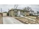 Charming home featuring a quaint front yard, long driveway, and single car detached garage at 7770 Kenwood St, Commerce City, CO 80022
