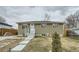 View of the home's exterior, with a well-maintained lawn and freshly painted facade at 7770 Kenwood St, Commerce City, CO 80022