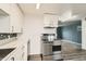 Modern kitchen featuring white cabinets, stainless steel appliances, and stylish flooring at 7770 Kenwood St, Commerce City, CO 80022