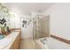Bright bathroom showcasing a soaking tub with glass shower door and a vanity with ample counter space at 661 Snowberry St, Longmont, CO 80503