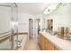 Bright bathroom featuring a soaking tub with glass shower door, double doors, and tan tile flooring at 661 Snowberry St, Longmont, CO 80503
