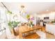 Open-concept dining area with a wooden table, bench seating, and views of the kitchen at 661 Snowberry St, Longmont, CO 80503