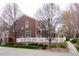 Side view of a two-story home with brick walls, white picket fence, and landscaping at 661 Snowberry St, Longmont, CO 80503