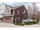 A brown two-story house with attached garage, well-kept lawn, and charming white picket fence at 661 Snowberry St, Longmont, CO 80503