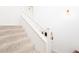 Bright staircase has neutral carpet and white banisters to a naturally lit and inviting landing at 661 Snowberry St, Longmont, CO 80503