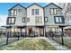 Modern townhome boasts a stylish gray and white facade, sleek windows, and a charming front patio with black metal fence at 1403 Yates St, Denver, CO 80204