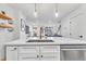 Modern kitchen island with white cabinets, sink, and dishwasher at 1403 Yates St, Denver, CO 80204