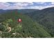 An aerial view highlights this property's secluded location surrounded by beautiful mountain trees at 10381 Hondah Dr, Littleton, CO 80127