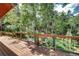 Wooden deck with railing offers a scenic view of the surrounding forest and peaceful natural setting at 10381 Hondah Dr, Littleton, CO 80127