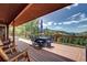 Enjoy outdoor living on this back deck with an umbrella table, chairs and wooded mountain view at 10381 Hondah Dr, Littleton, CO 80127