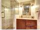 Modern bathroom featuring a walk in shower with beautiful tile work and granite topped vanity at 10381 Hondah Dr, Littleton, CO 80127