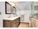 Bathroom featuring a glass-enclosed shower, dual sinks with a marble countertop, and wood tile flooring at 10381 Hondah Dr, Littleton, CO 80127