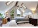 Bright bedroom featuring a large window with mountain views and vaulted ceiling with skylights at 10381 Hondah Dr, Littleton, CO 80127
