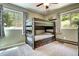 Bedroom featuring rustic bunk beds with storage drawers and natural light from large windows at 10381 Hondah Dr, Littleton, CO 80127