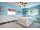 Charming bedroom with blue walls, large windows, ceiling fan, and white wood trim at 10381 Hondah Dr, Littleton, CO 80127