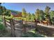 Stunning log home nestled in the trees on horse property, with a fence and two horses at 10381 Hondah Dr, Littleton, CO 80127