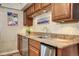 Kitchenette area with granite countertop, tile backsplash, stainless steel appliances and stylish cabinets at 10381 Hondah Dr, Littleton, CO 80127
