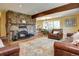 Spacious living room featuring stone fireplace, an area rug, and lots of natural light at 10381 Hondah Dr, Littleton, CO 80127