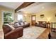 Bright living room with an area rug, wood beam, and ample natural light at 10381 Hondah Dr, Littleton, CO 80127
