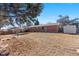 Expansive backyard featuring a brick home, shed, and potential garden area, perfect for outdoor living at 15303 E 10Th Ave, Aurora, CO 80011