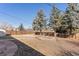Open backyard with mature trees, wooden fence, and a designated garden plot for landscaping or relaxation at 15303 E 10Th Ave, Aurora, CO 80011