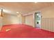 A large basement has red carpet, and painted wood paneling with access to a laundry area at 15303 E 10Th Ave, Aurora, CO 80011