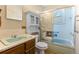 A full bath features a shower and tub combination with sliding glass doors and a vintage vanity at 15303 E 10Th Ave, Aurora, CO 80011