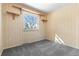Small carpeted bedroom features a window with wooden shelves on either side, providing space for storage at 15303 E 10Th Ave, Aurora, CO 80011
