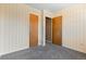 A carpeted bedroom with light wallpaper has two wooden doors and a small, well-lit area at 15303 E 10Th Ave, Aurora, CO 80011