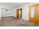 A carpeted bedroom features a window, a closet with a mirrored door, and neutral colored walls at 15303 E 10Th Ave, Aurora, CO 80011