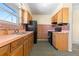Functional kitchen featuring retro details, wood cabinets, and black appliances at 15303 E 10Th Ave, Aurora, CO 80011